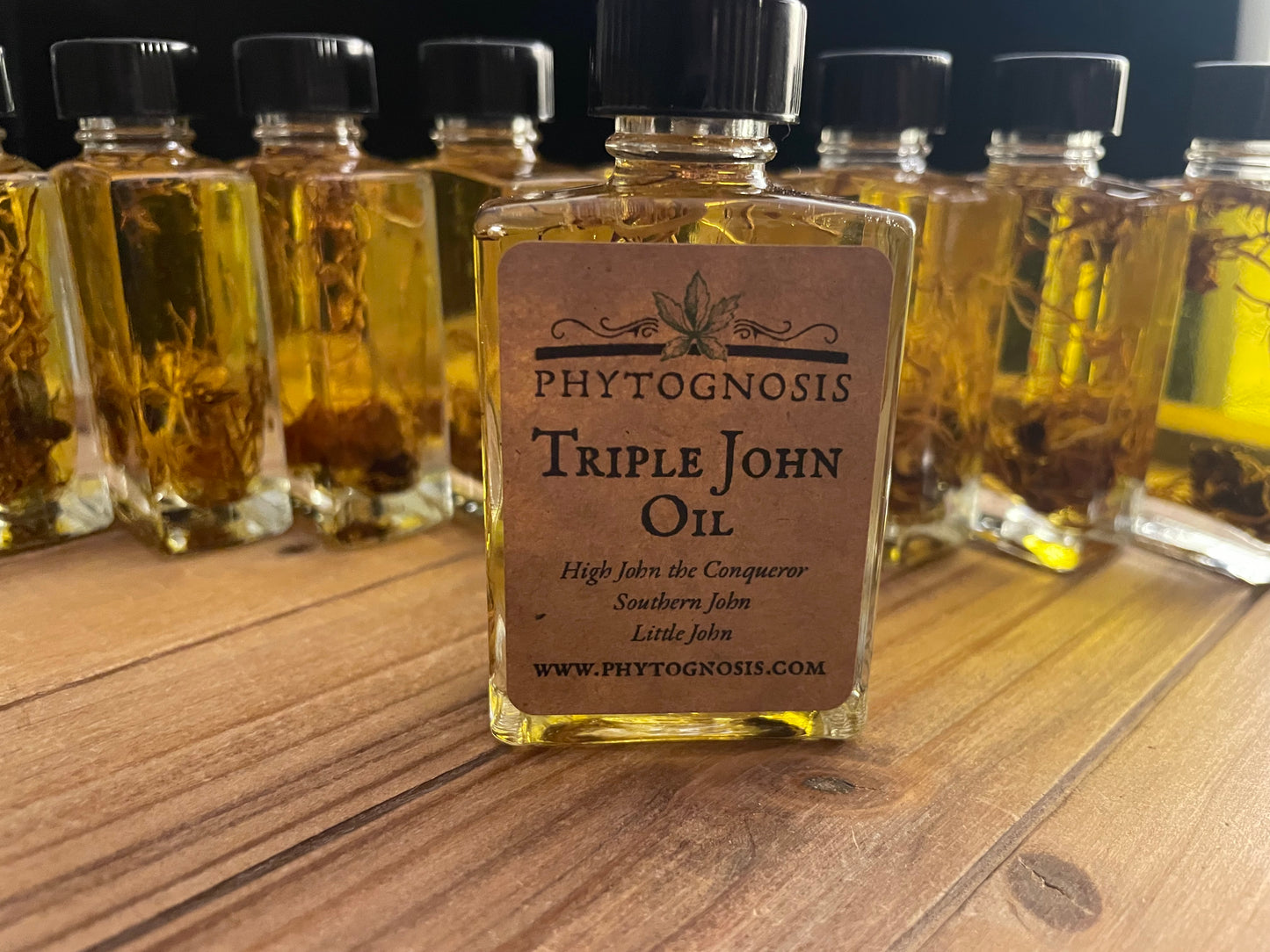 Close-up of Triple John Oil label showing ingredients list including High John the Conqueror, Little John to Chew, and Southern John in jojoba oil base for hoodoo rootwork