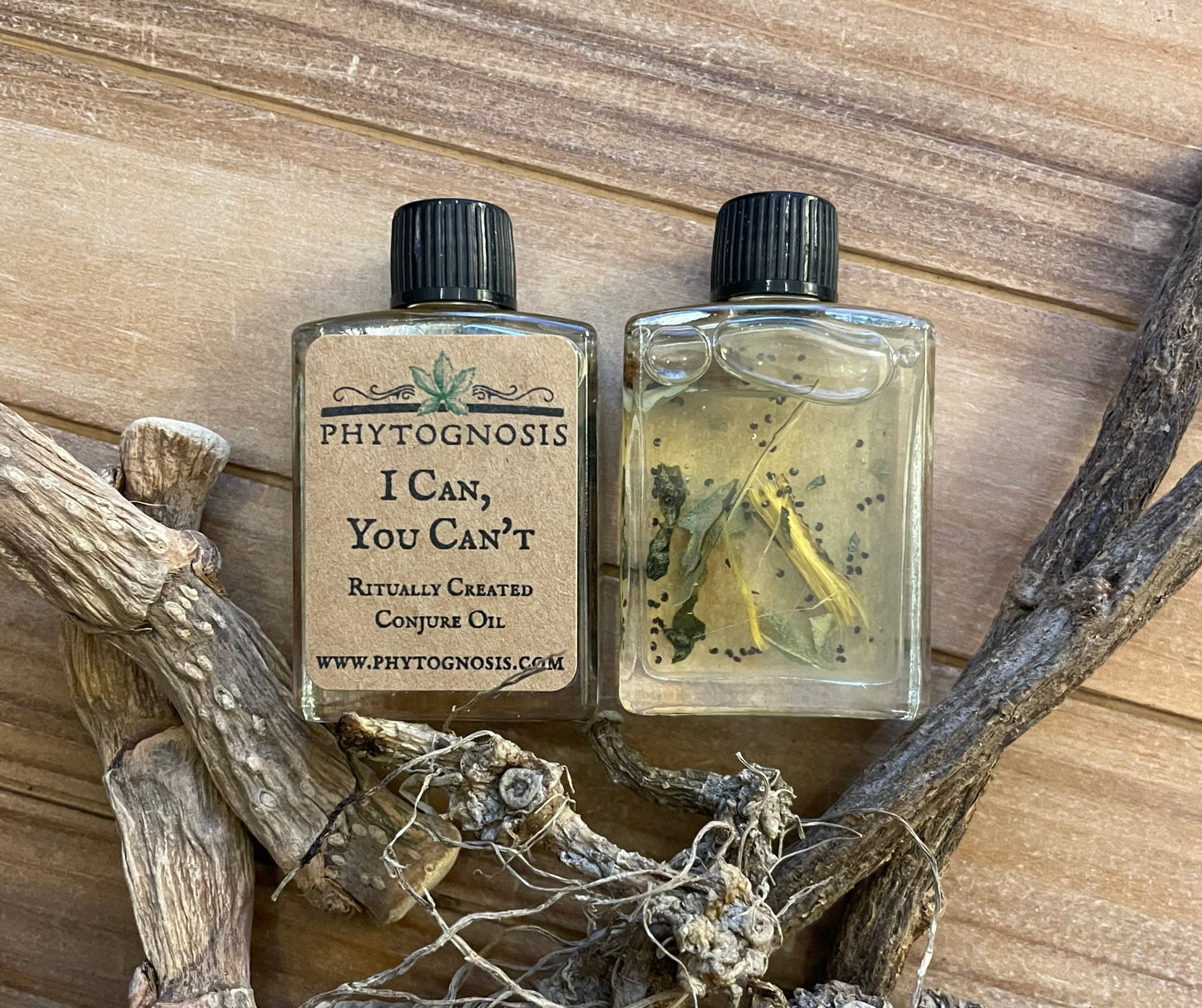 Two bottles of Phytognosis oil with a wooden background and branches.