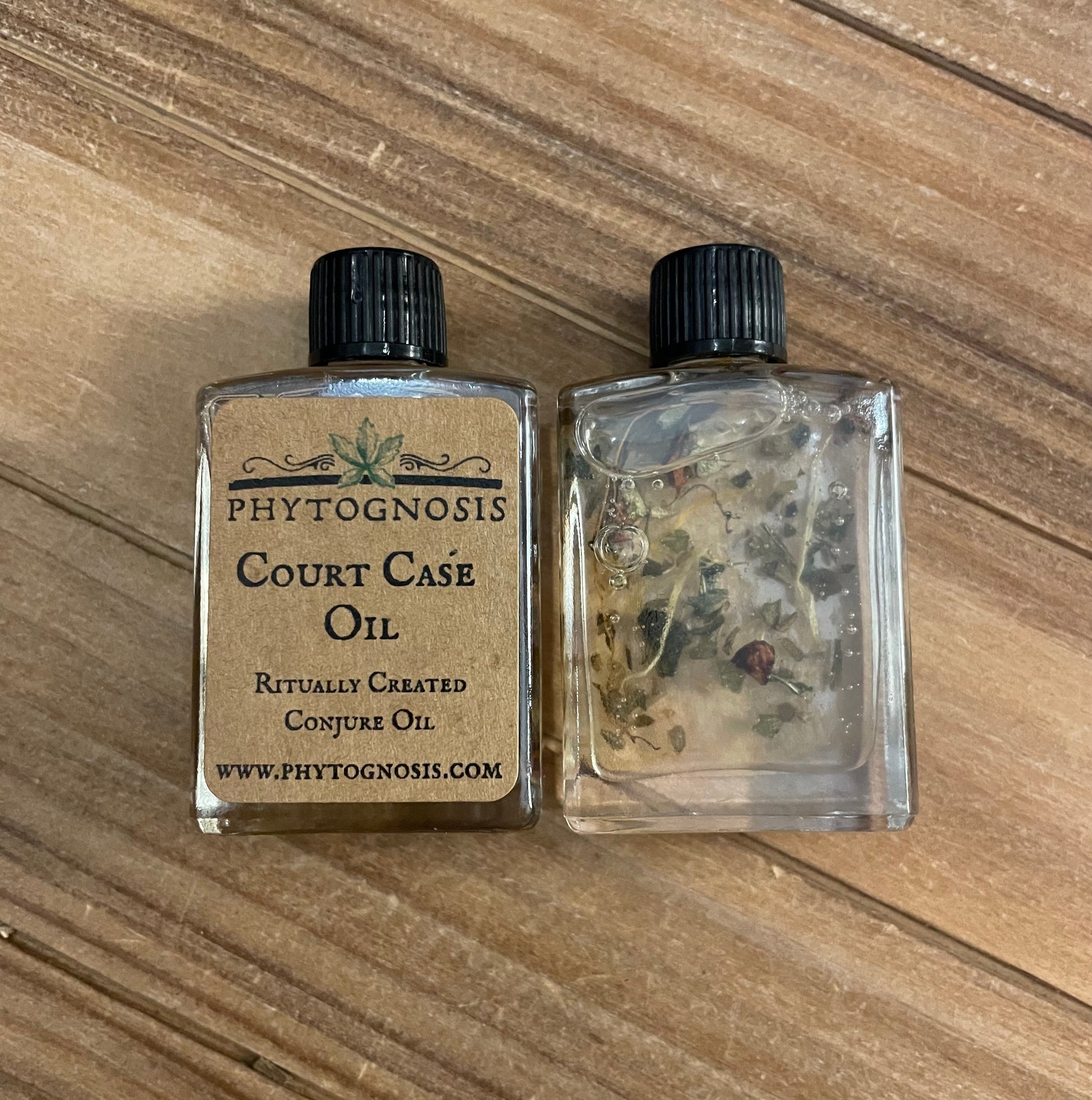 Two small bottles of Phytognosis Court Case Oil on a wooden surface