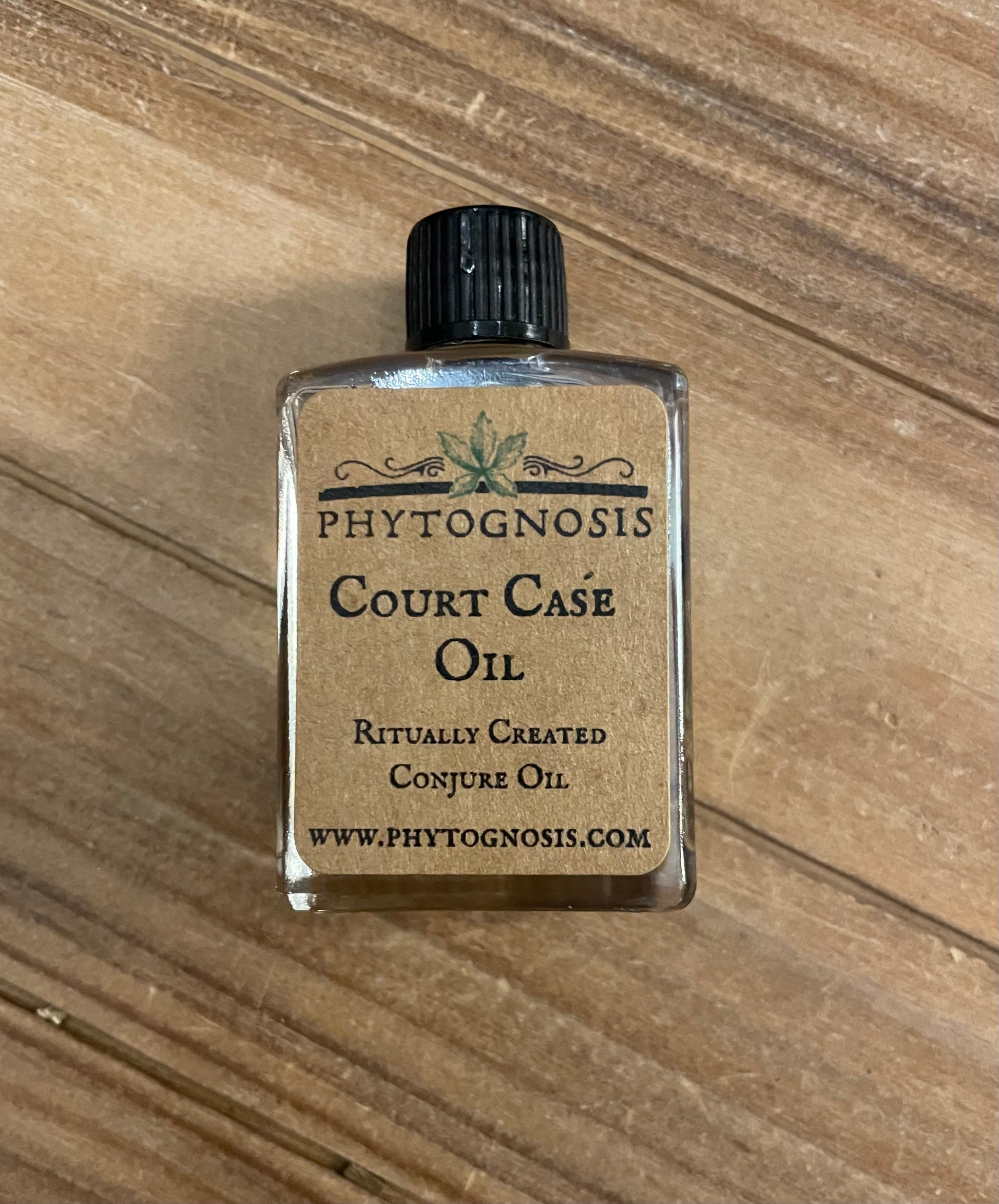 Small bottle of Phytognosis Court Case Oil on a wooden surface