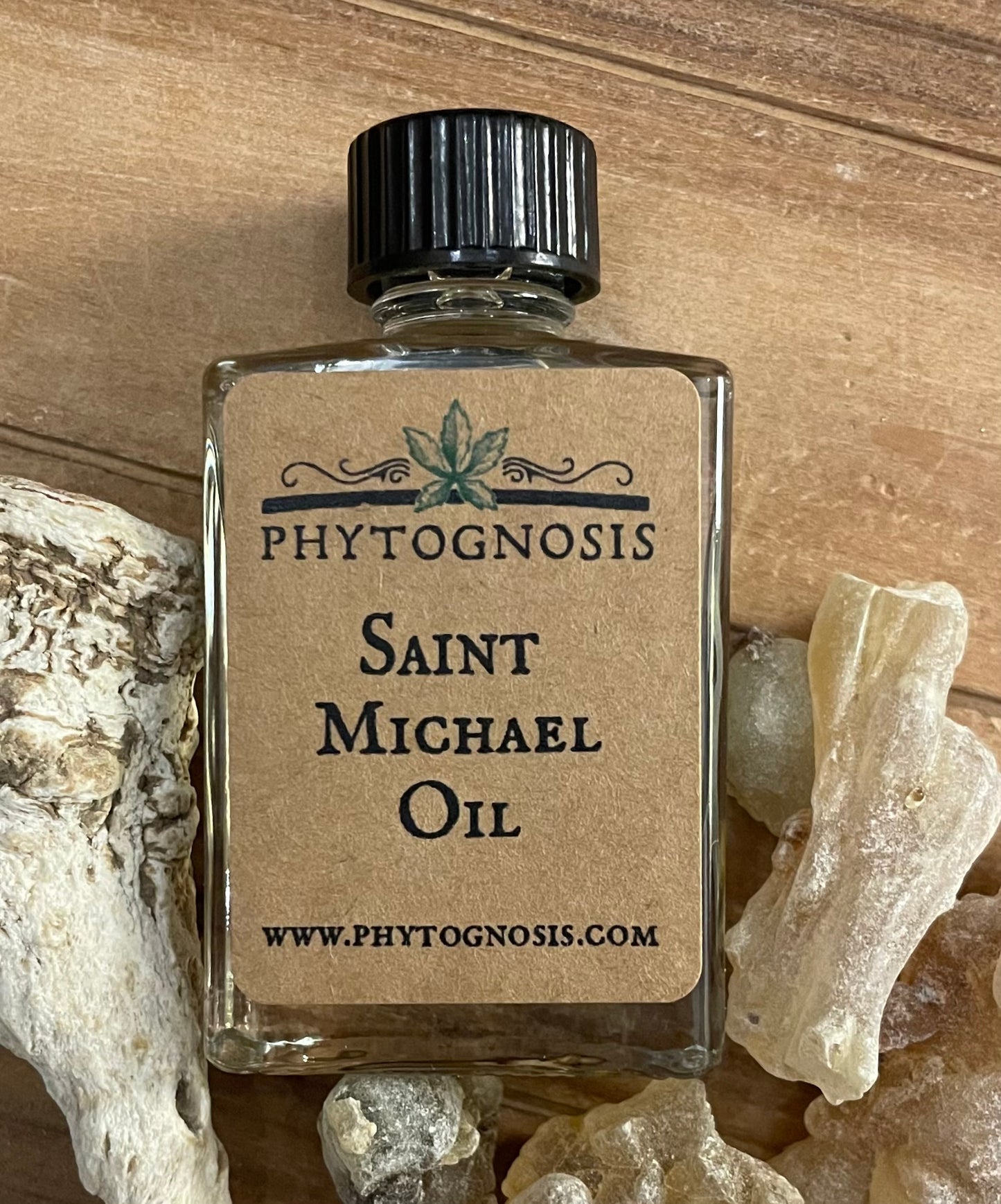 Bottle of Saint Michael Oil by Phytognosis on a wooden surface with roots.
